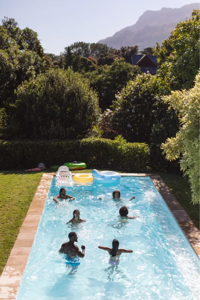 Kids playing a in a pool surrounded by trees