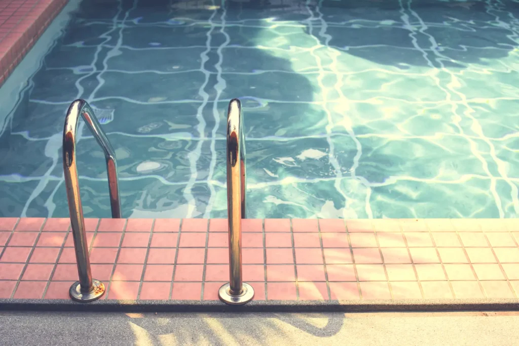 Ladder into swimming pool in summer time